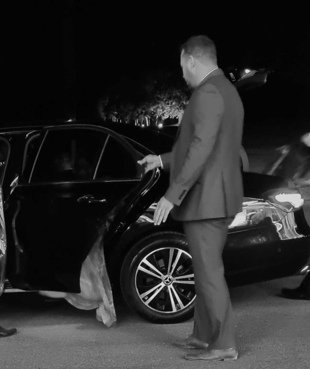 Private chauffeur opening car door